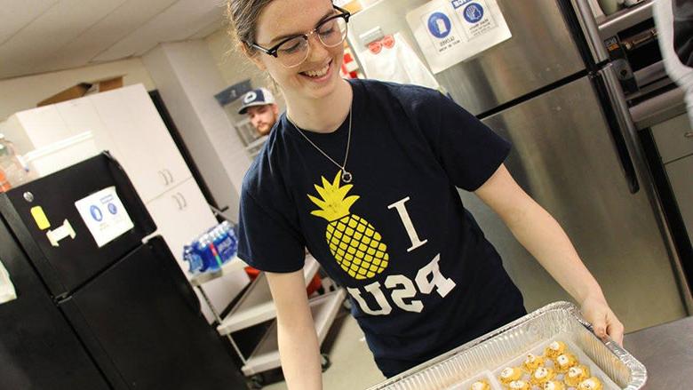 A student at Opportunity House carrying a tray of appetizers